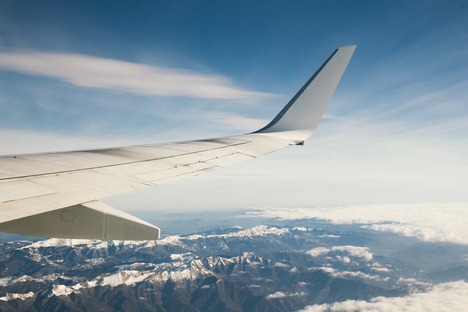 Survol d'une chaîne de montagne en avion. L'aéronautique joue un rôle important dans la création de BOILISÉ, que ce soit pour les voyages ou les carrières de ses fondateurs.