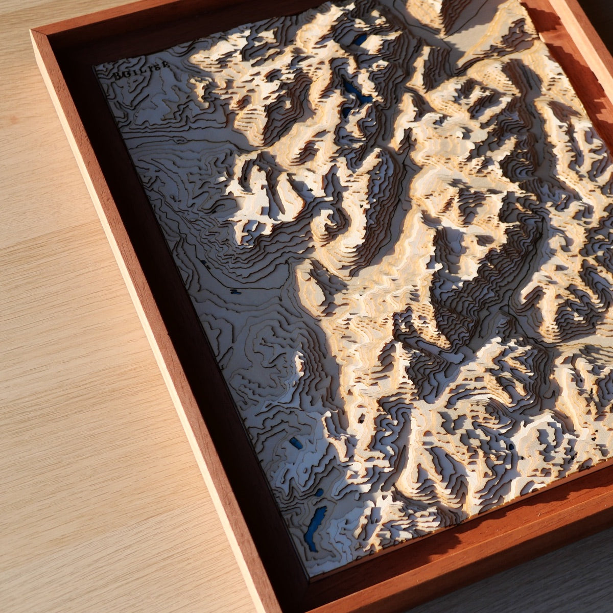 Relief de la vallée de Chamonix au soleil couchant représenté avec de fines couches de bois assemblées à la main