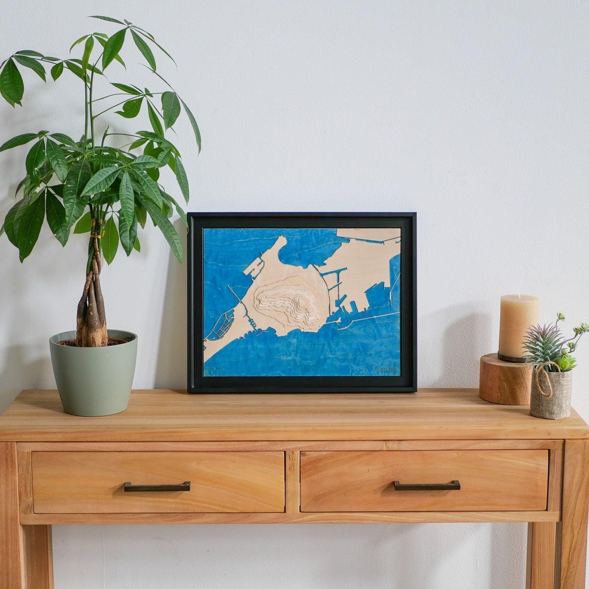 Carte topographique de Sète posée sur une commode en bois à l'entrée d'une maison