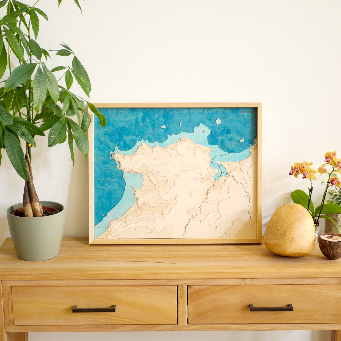 Décoration en bois avec une commode, un galet de chêne et un tableau topographique d'Erquy