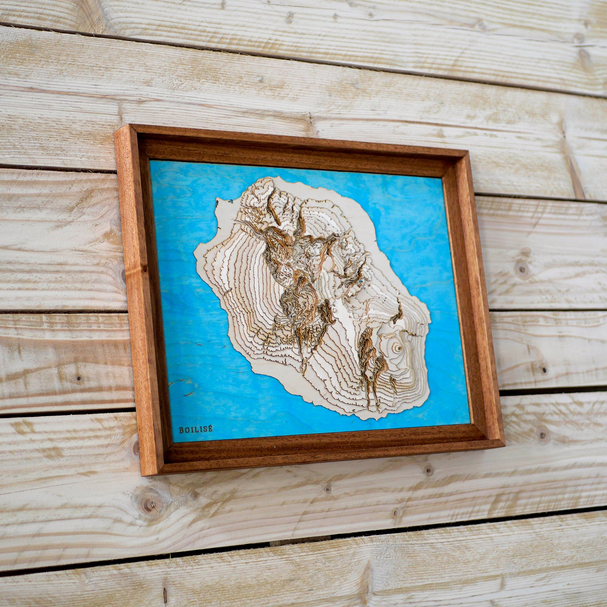 Tableau de l'île de la Réunion accroché à un mur de bois.