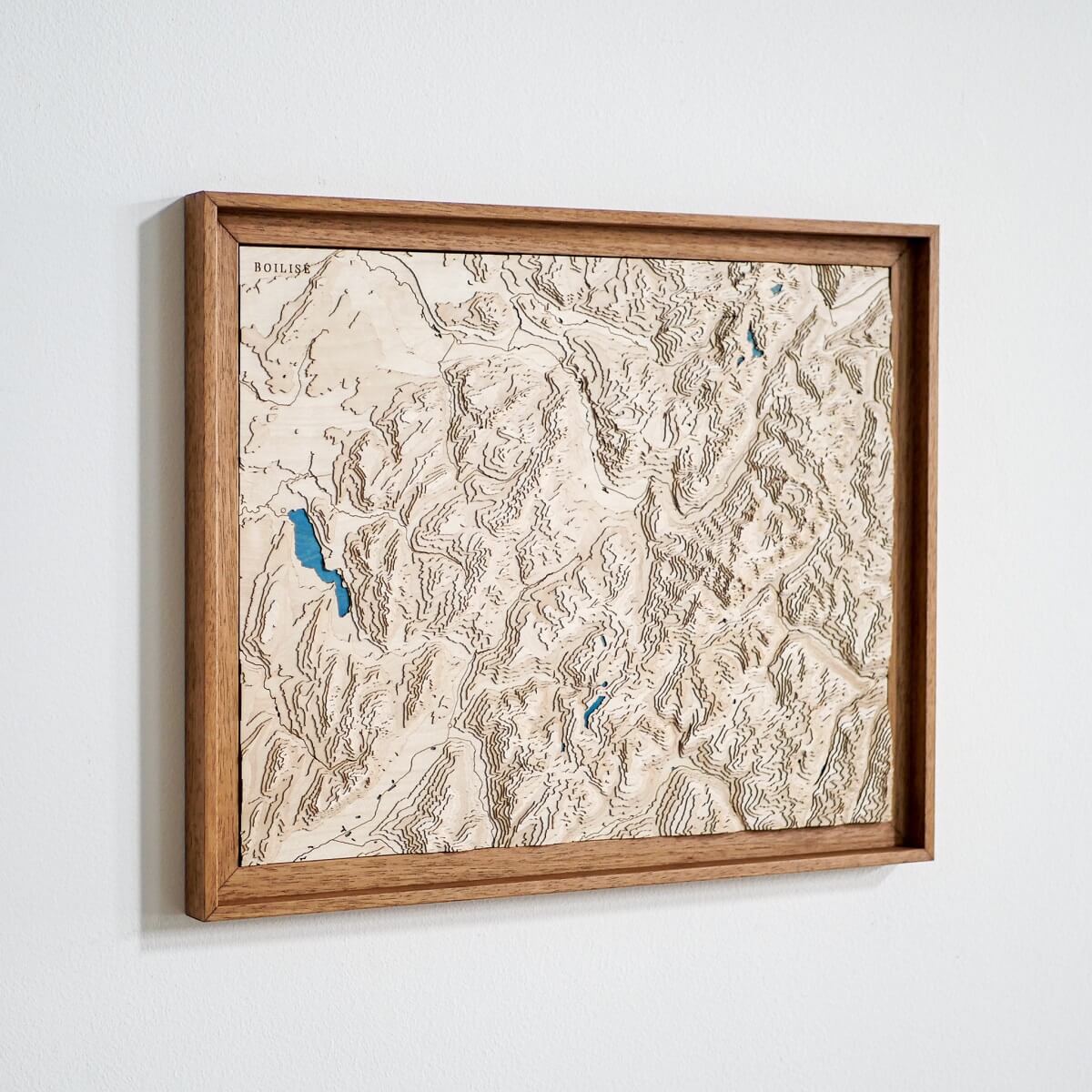 Tableau de Megève en relief et en bois accroché au mur.